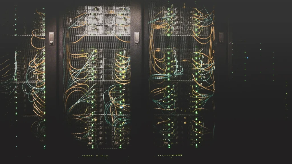 Rows of server racks in a data centre, threaded with network cables and small status lights
