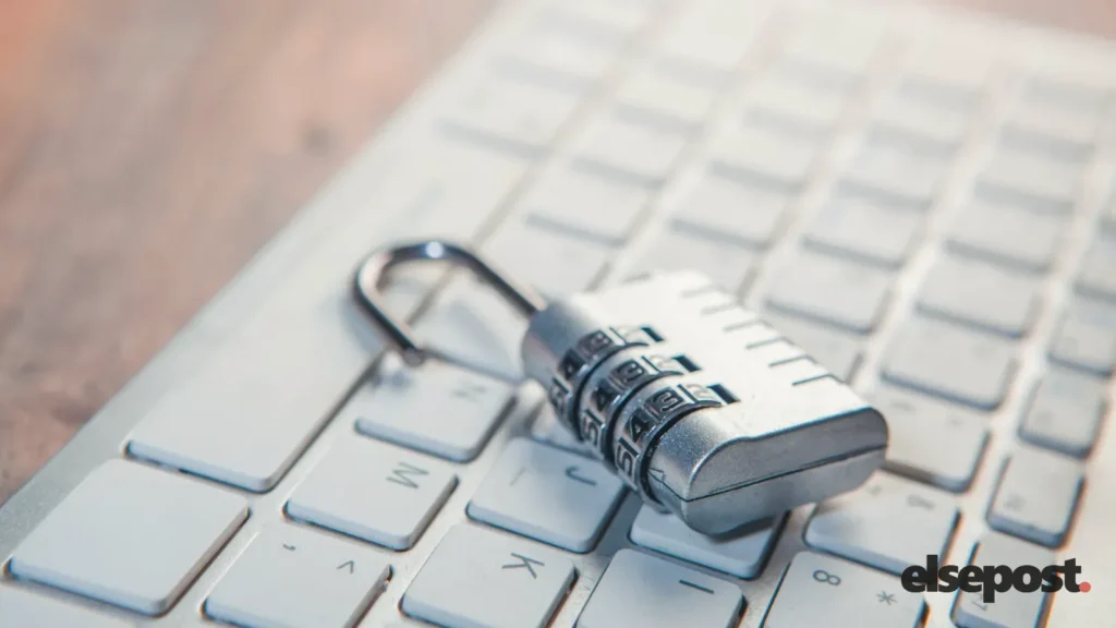 An open combination padlock resting on a white computer keyboard