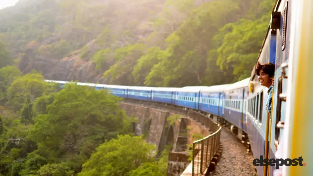 A passenger train curving through green hills