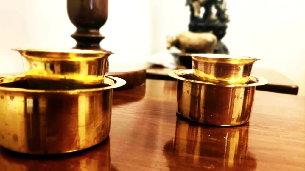 Brass vessels and lamps on a table, the kind of items people clean brass puja items for before Diwali