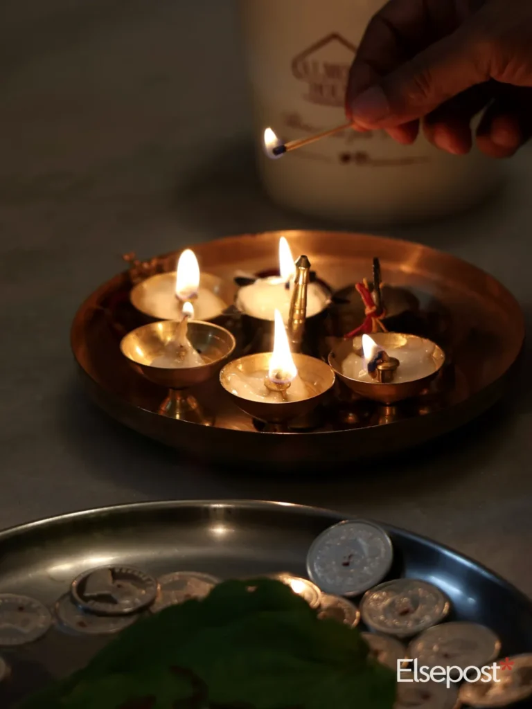 Hand lighting oil lamps on a brass plate, for cleaning brass puja items