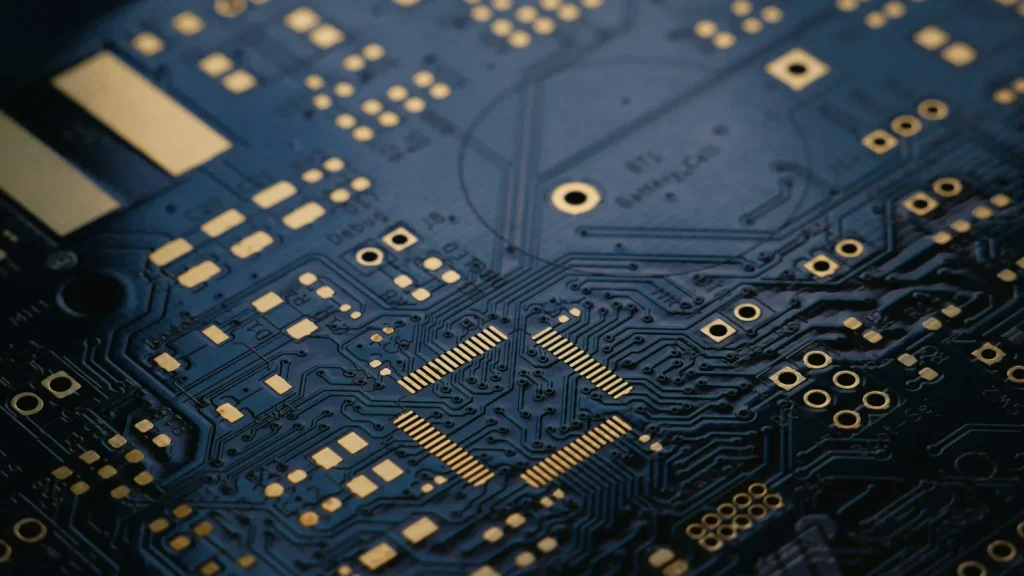 Close-up of a dark printed circuit board with gold contacts