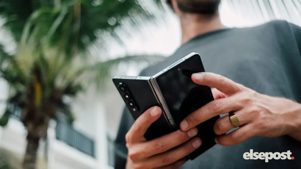 Hands opening a foldable smartphone