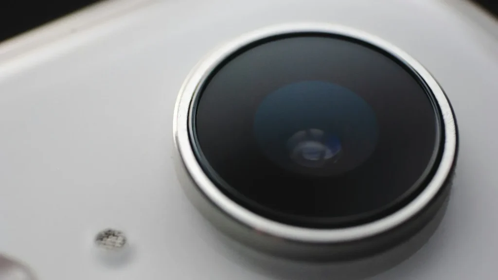 Close-up of a large camera lens on the back of a white smartphone