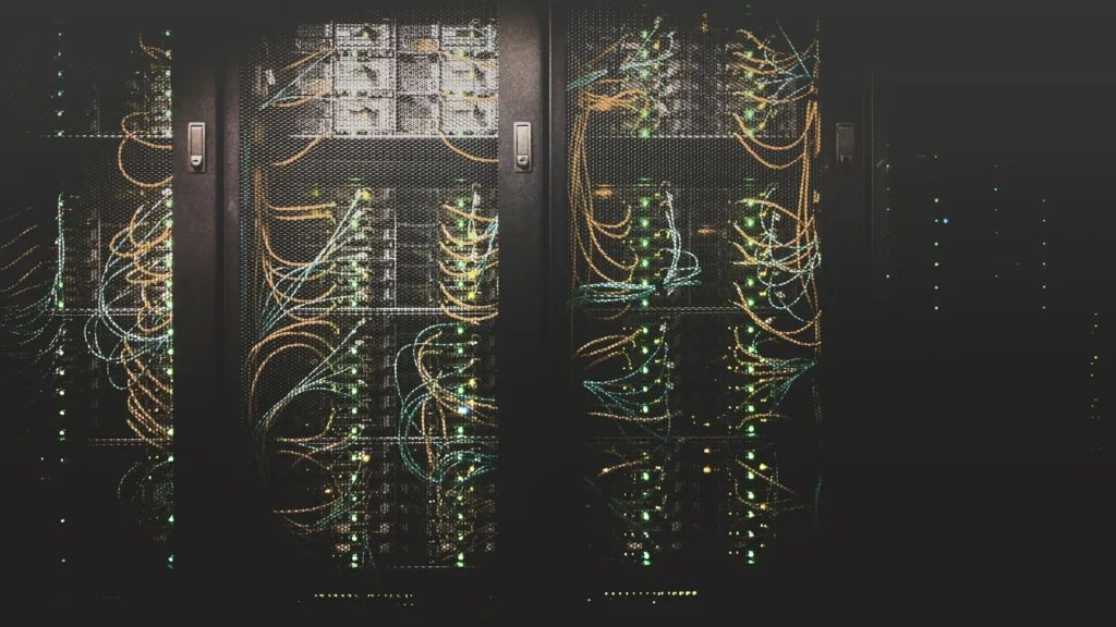 Rows of servers with coloured network cables in a data centre