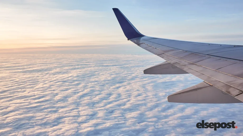 Airplane wing above white clouds during the day