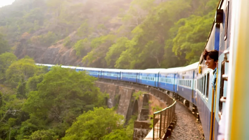 A passenger train curving through green hills